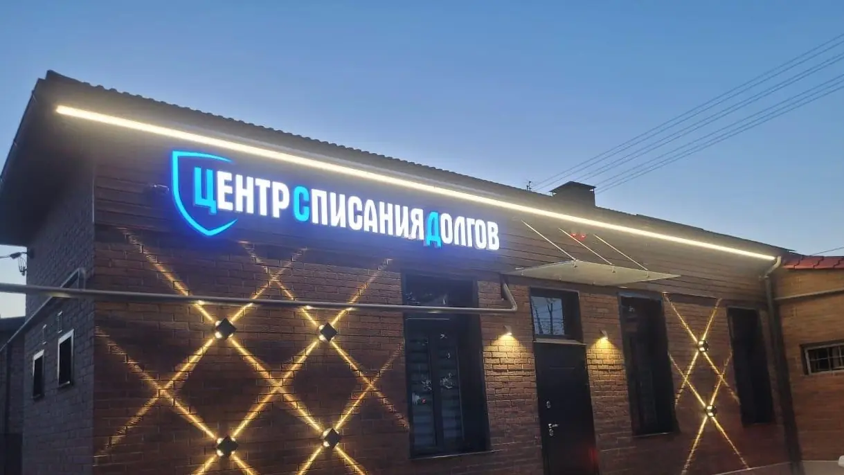 Вывеска Центра списания долгов вечером