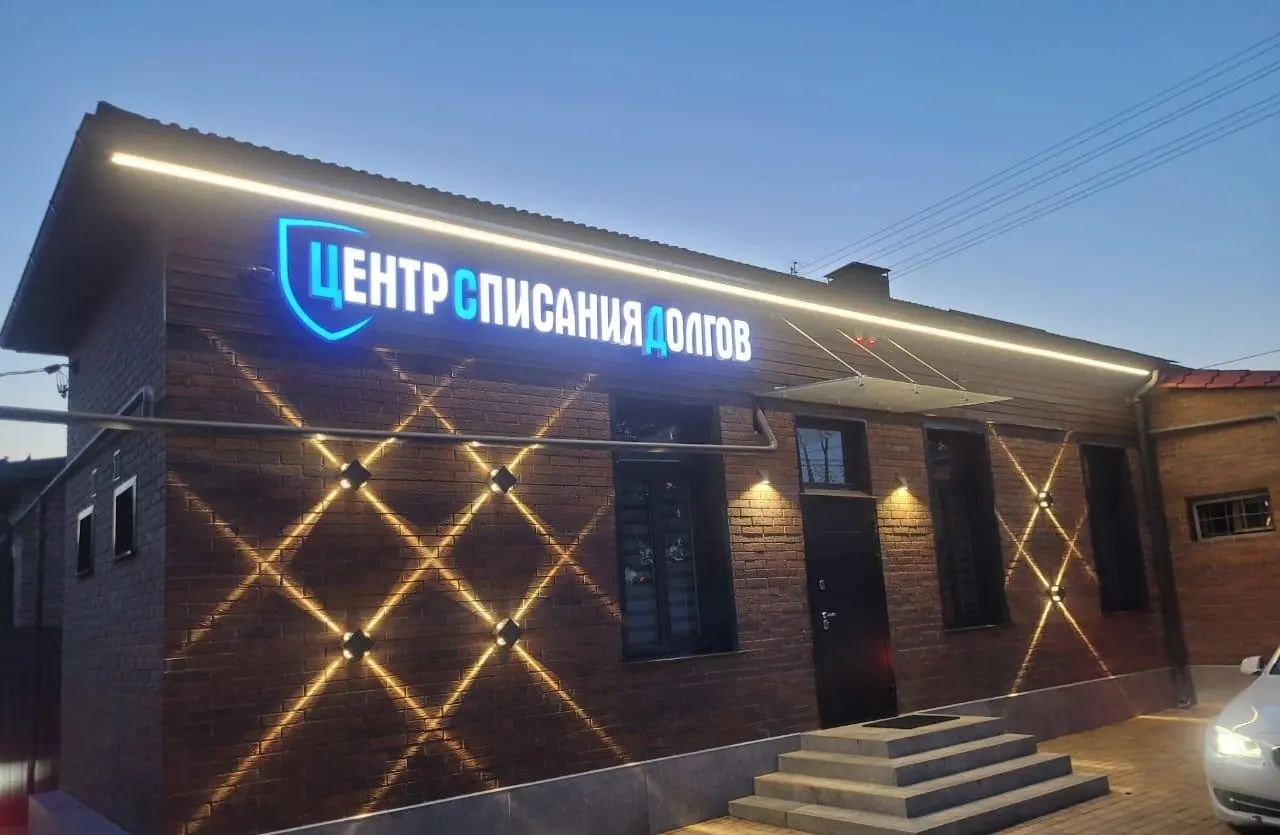 Вывеска Центра списания долгов вечером